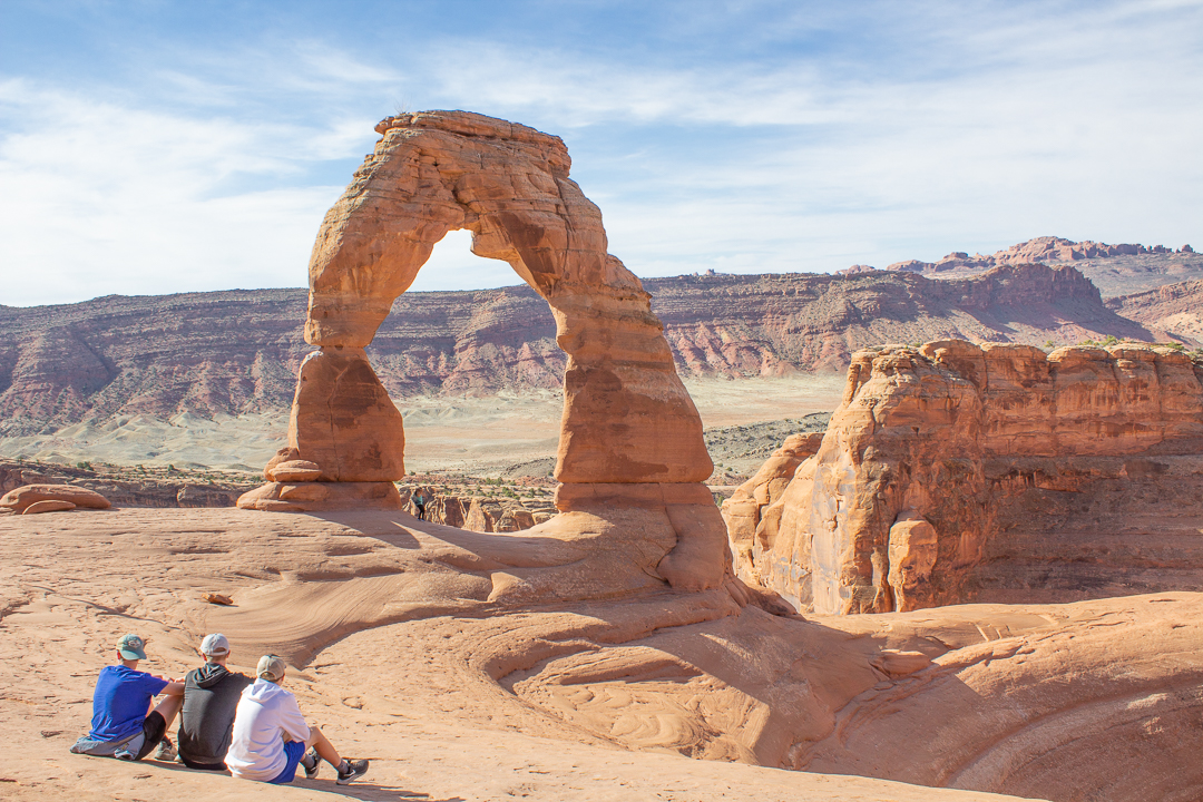 boys sitting at Delicate Arch
